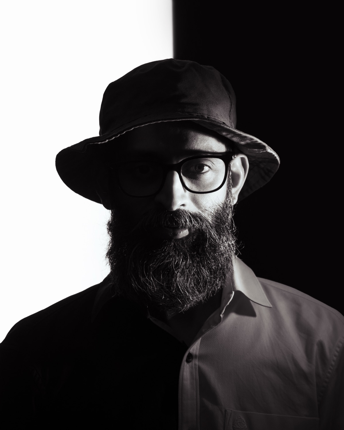 Robin, founder and mentor of Lightdots Academy — split-light black and white portrait